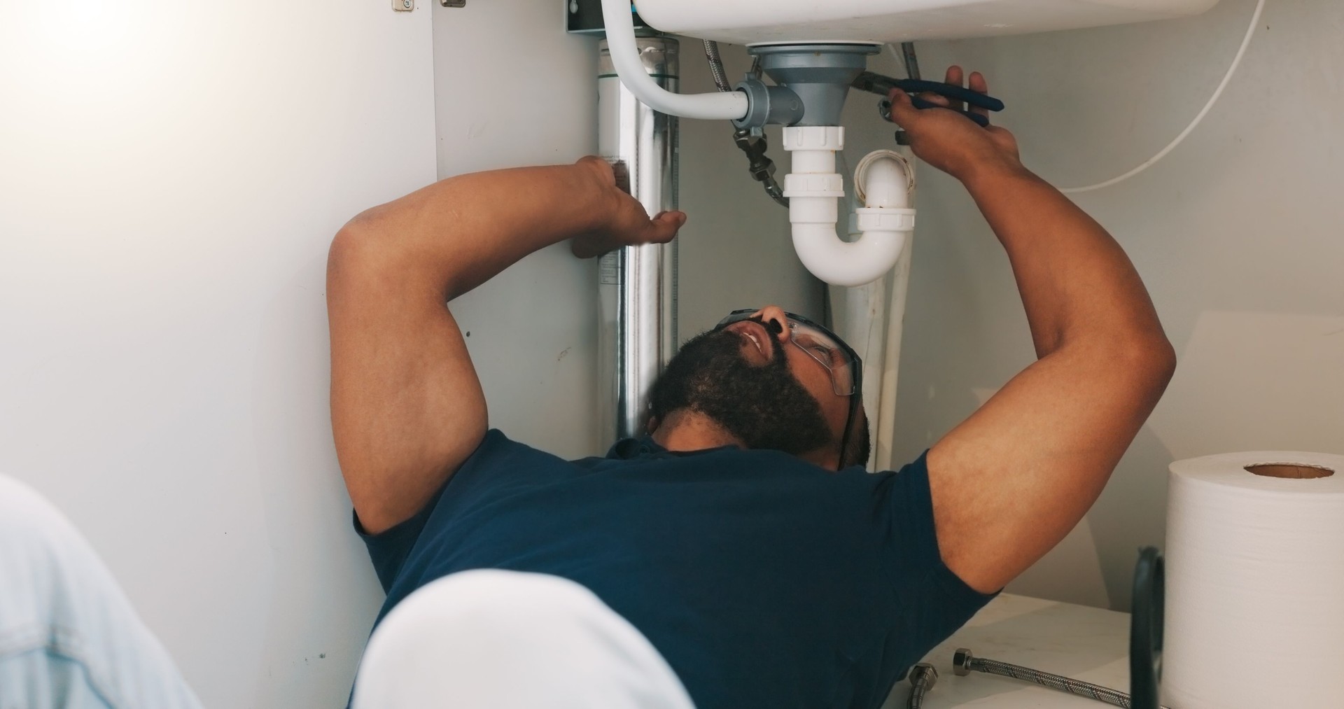 Plumber black man, kitchen and sink maintenance with tools, focus and pipe repair for drainage in home. Entrepreneur handyman, plumbing expert or small business owner in house for fixing water system